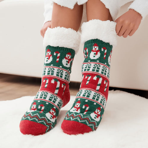 The Foozie™ Christmas Snowman slipper socks, green and red snowman and candy cane knit, hands pulling up the sherpa cuffs