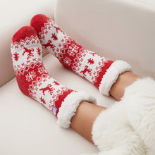 Load image into Gallery viewer, The Foozie™ Christmas Reindeer slipper socks, crossed feet on the sofa with the sherpa cuffs folded down
